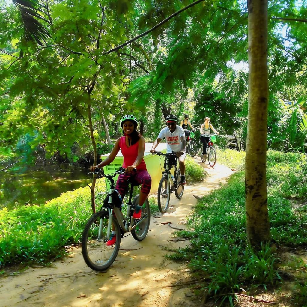 Cyclists riding along a shaded park path in Sri Nakhon Khuean Khan Park, Bang Krachao