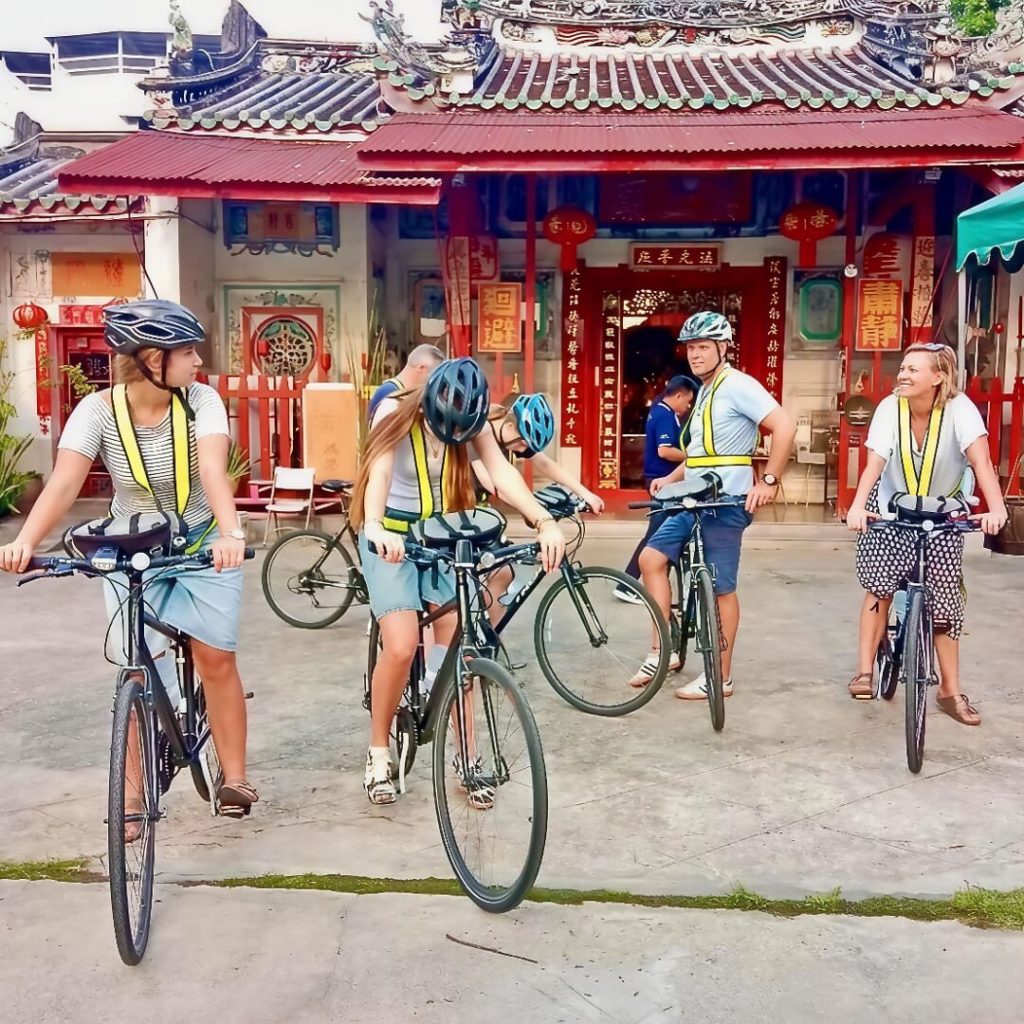 Cyclists outside a Chinese shrine in Bangkok