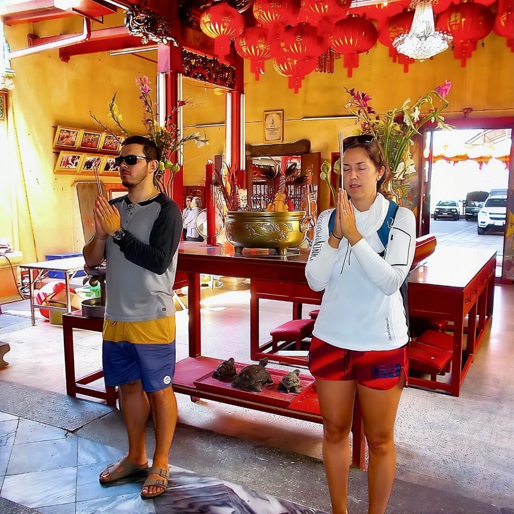 Guests making an incense offering inside Chow Sue Kong Shrine in Talat Noi, Bangkok