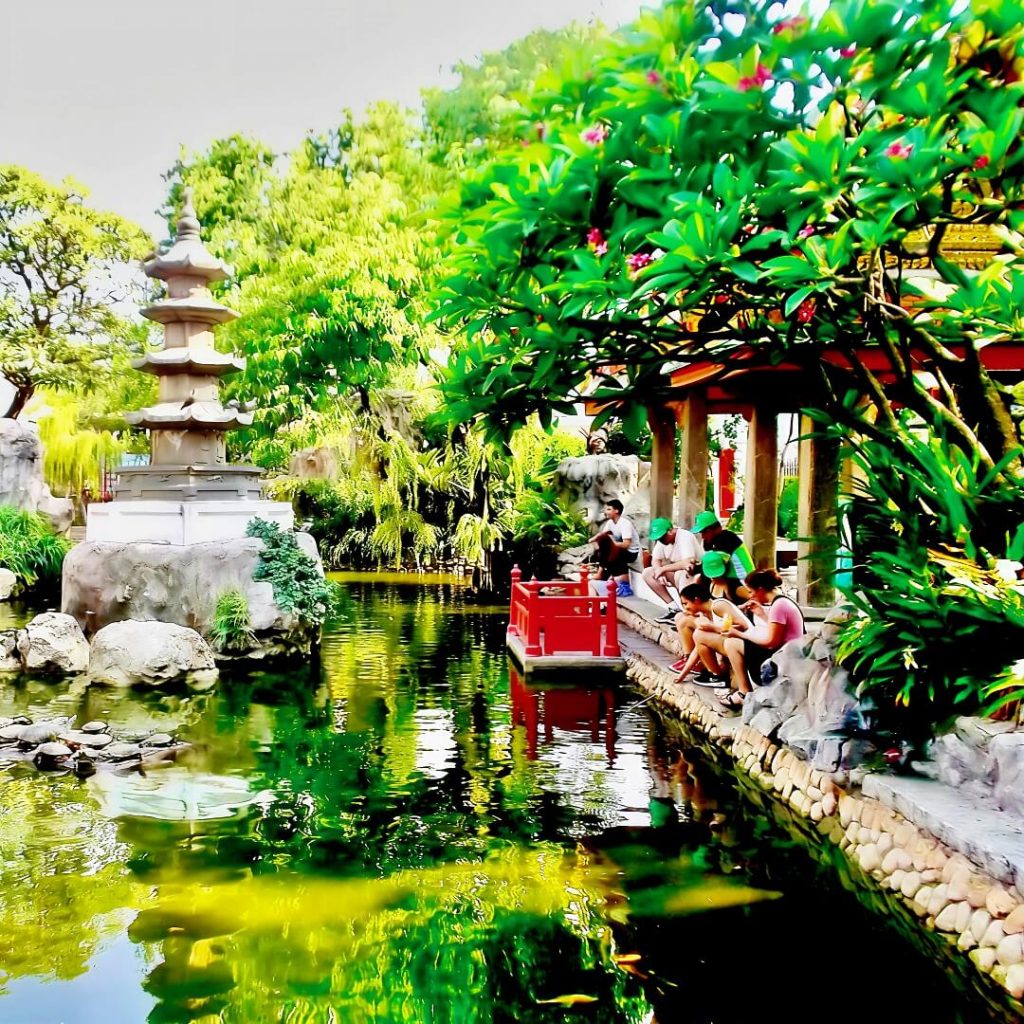 Guests resting beside the turtle pond at Wat Prayoon in Bangkok