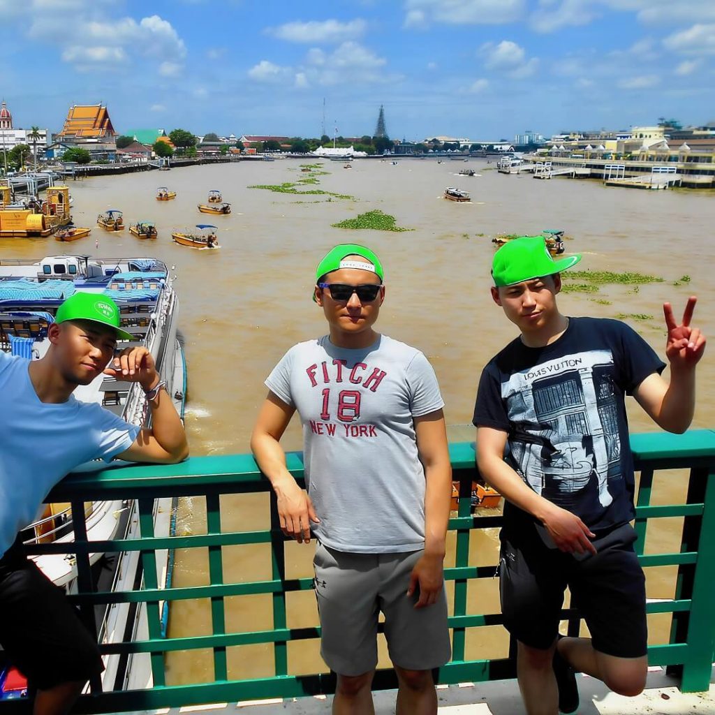 Guests standing on Memorial Bridge overlooking the Chao Phraya River and Bangkok’s Old Town