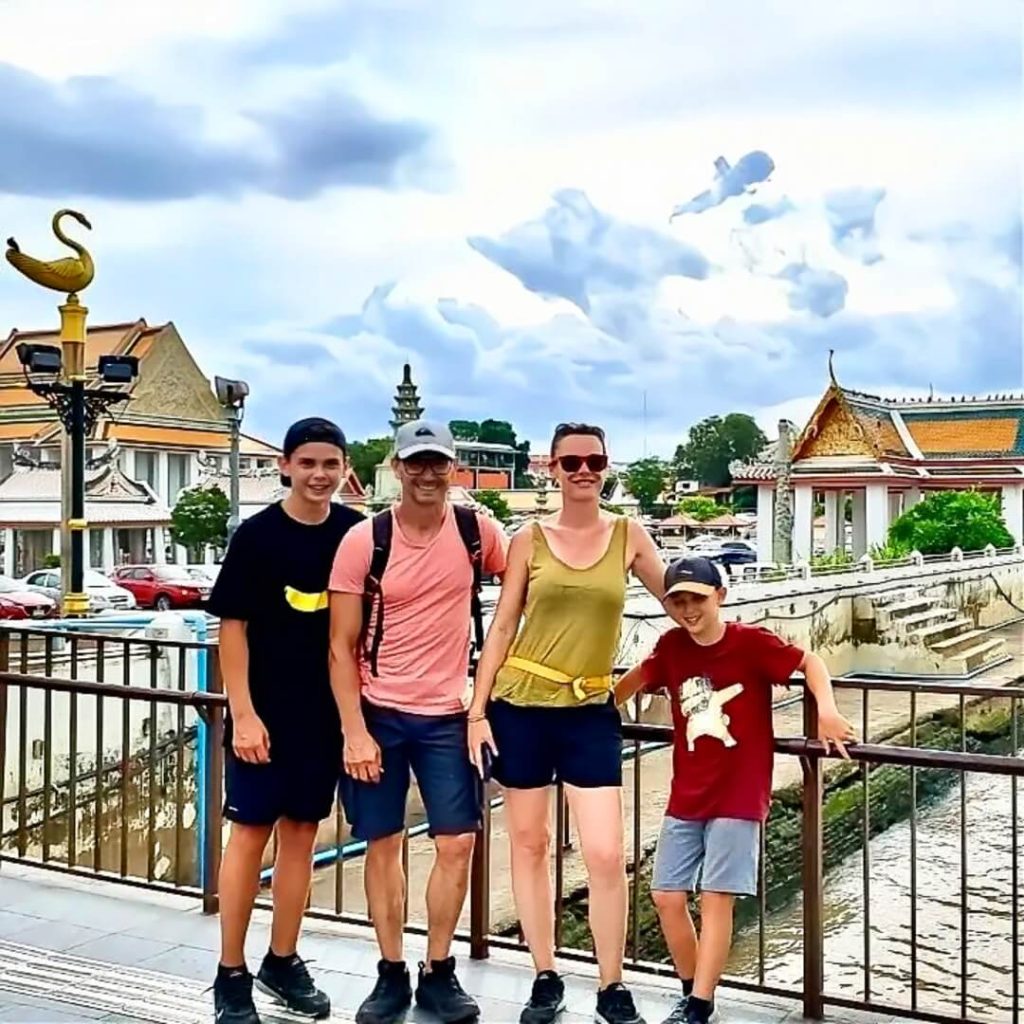 Guests walking along a riverside path beside the Chao Phraya River in Bangkok