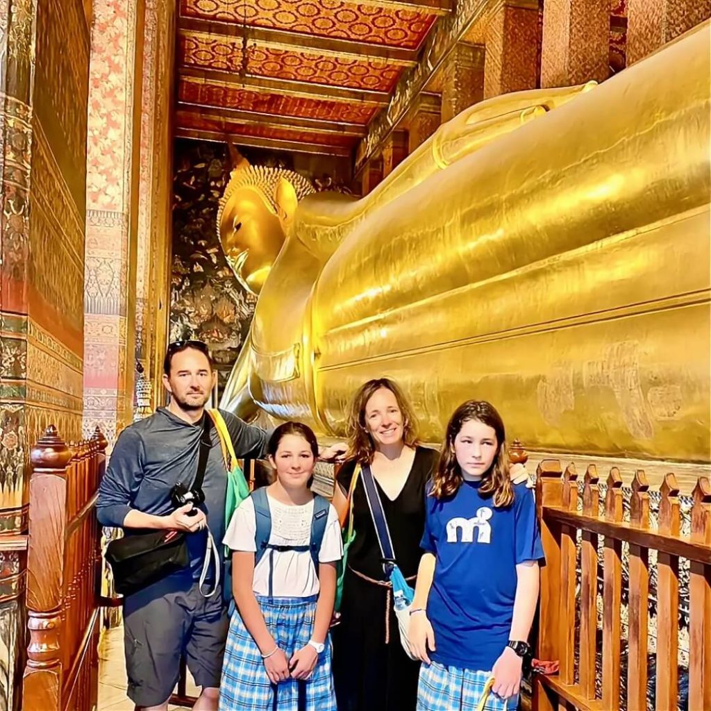Guests standing beside the Reclining Buddha at Wat Pho in Bangkok