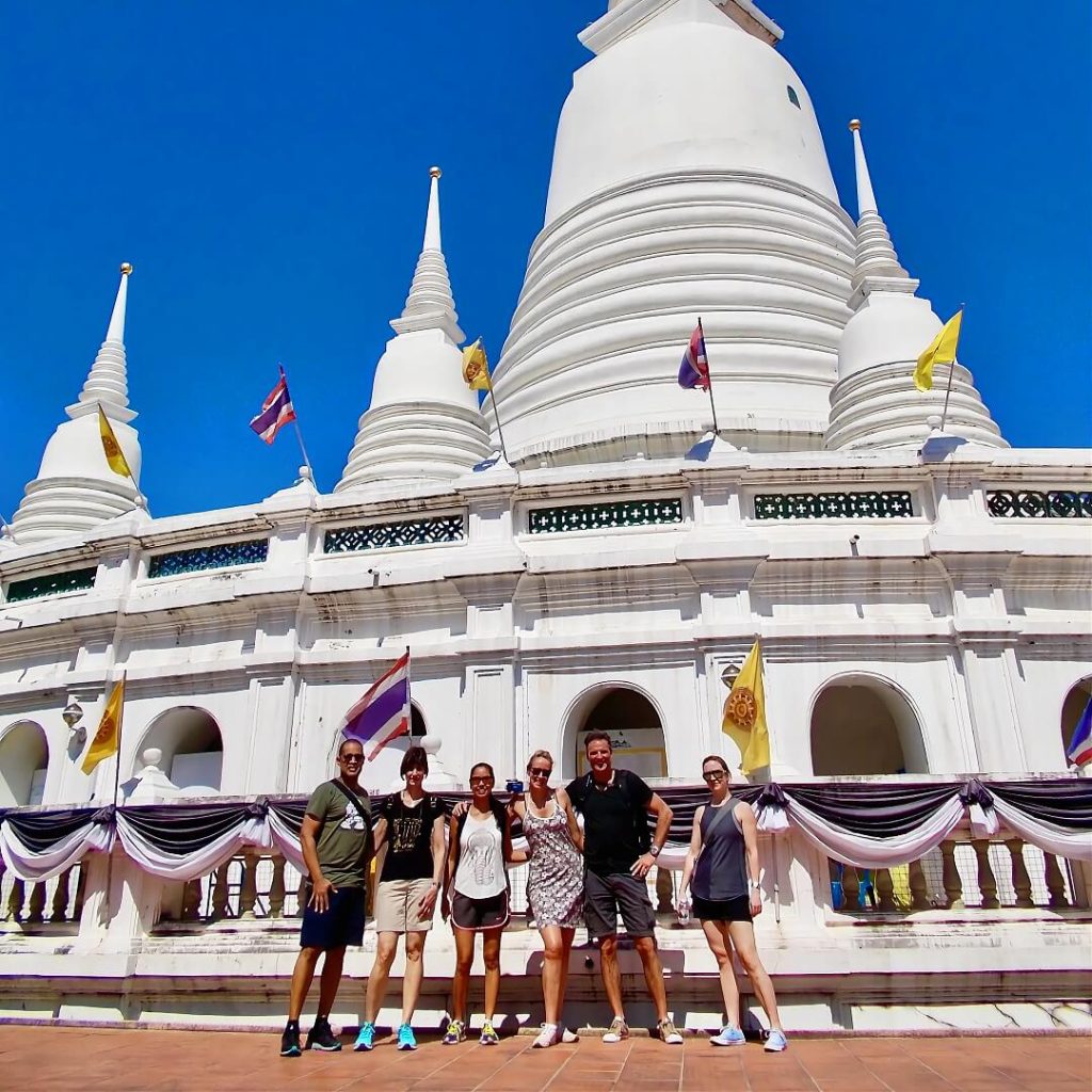 Guests standing in front of the white chedi at Wat Prayoon temple in Bangkok
