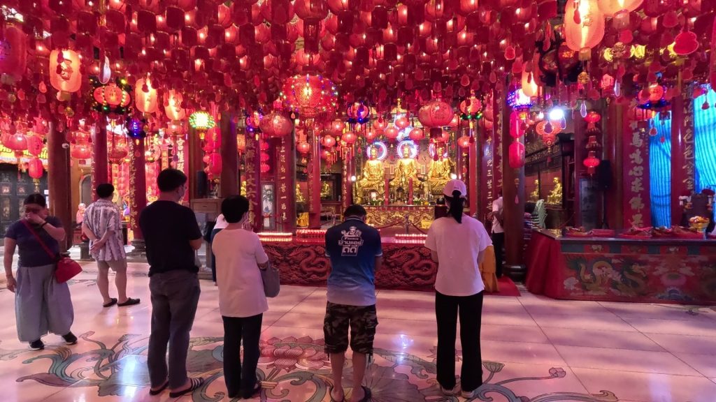 Locals praying, lighting incense and making offerings inside Wat Mangkong, Chinatown

