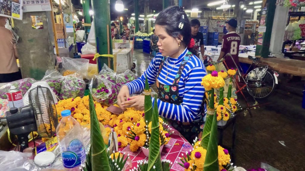 A young worker creating Bai Sri arrangements.