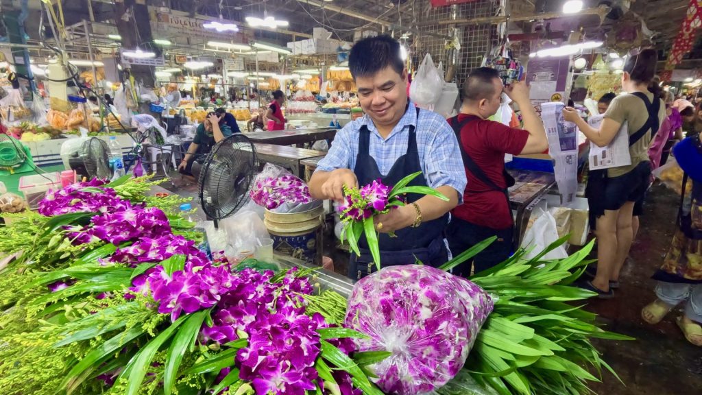 Market vendor making Orchid Bouquets 