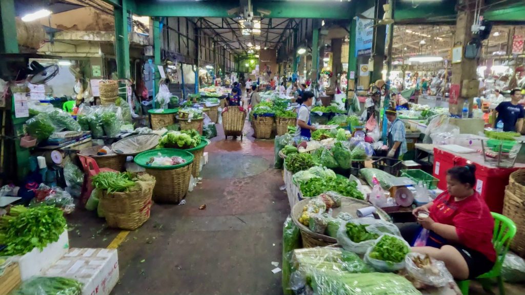 An array of Thai herbs and vegetables for sale inside the market