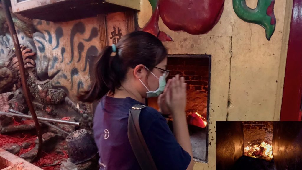 Close-up of joss paper burning at a Taoist shrine in Bangkok—part of a traditional ritual to honour ancestors.