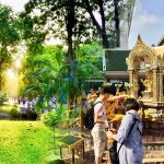 Cycling from Lumphini Park to Erawan Shrine showing morning light in the park and worshippers at the shrine in Bangkok