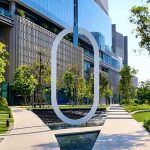 Cycling around One Bangkok with modern architecture, landscaped gardens, water features and the O landmark in the foreground