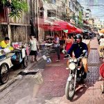 Cycling from Wat Hua Lamphong to Wat Mangkon showing quiet backstreet and busy Chinatown market street in Bangkok