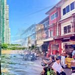 Sathon Pier riverside Bangkok with skyline contrasted with vegetable market near Pak Khlong Talat Flower Market along cycling route