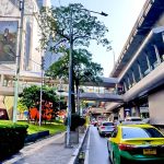 Cycling from Gaysorn Centre to Nana BTS showing Sukhumvit Road with shopping complex, BTS Skytrain and busy traffic in Bangkok
