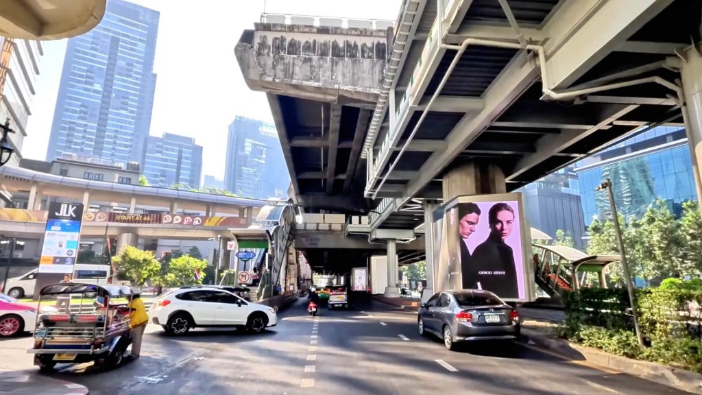 Cycling towards Nana BTS Station along Sukhumvit Road in Bangkok.