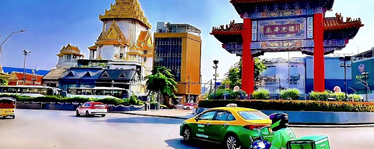 Chinatown Gate on Yaowarat Road Bangkok with light traffic and temple in background