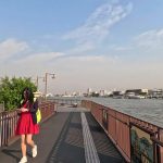 Pedestrian walking along the Chao Phraya riverside walkway in Bangkok