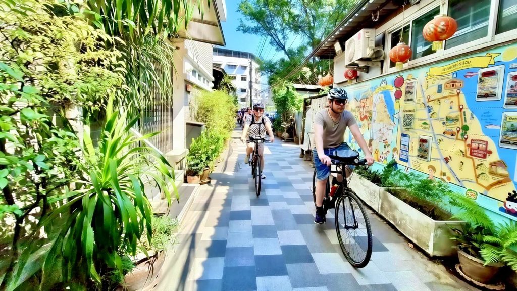 Cyclist riding through a narrow lane in Talat Noi Bangkok