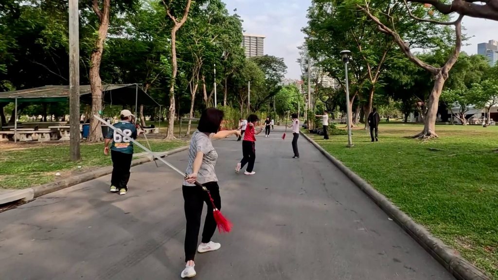 Morning exercise routines in a quieter section of Lumphini Park, Bangkok
