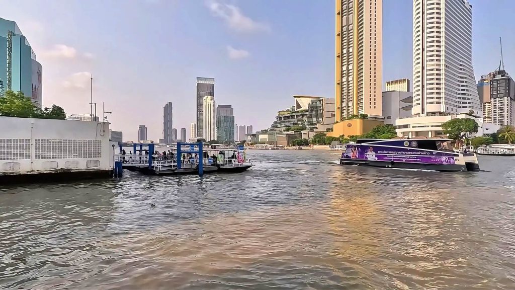 Ferry arriving at River City Bangkok with commuters disembarking along the Chao Phraya River