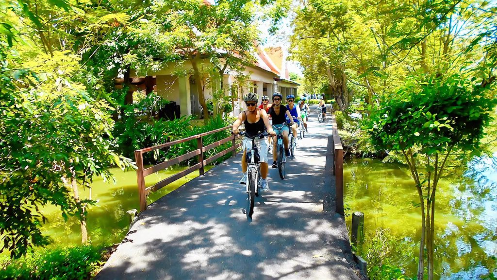 Cycling path through Sri Nakhon Khuean Khan Park with trees and lakes in Bangkok
