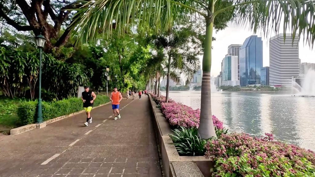 Morning walking and jogging beside the lakefront at Benchakitti Park in Bangkok