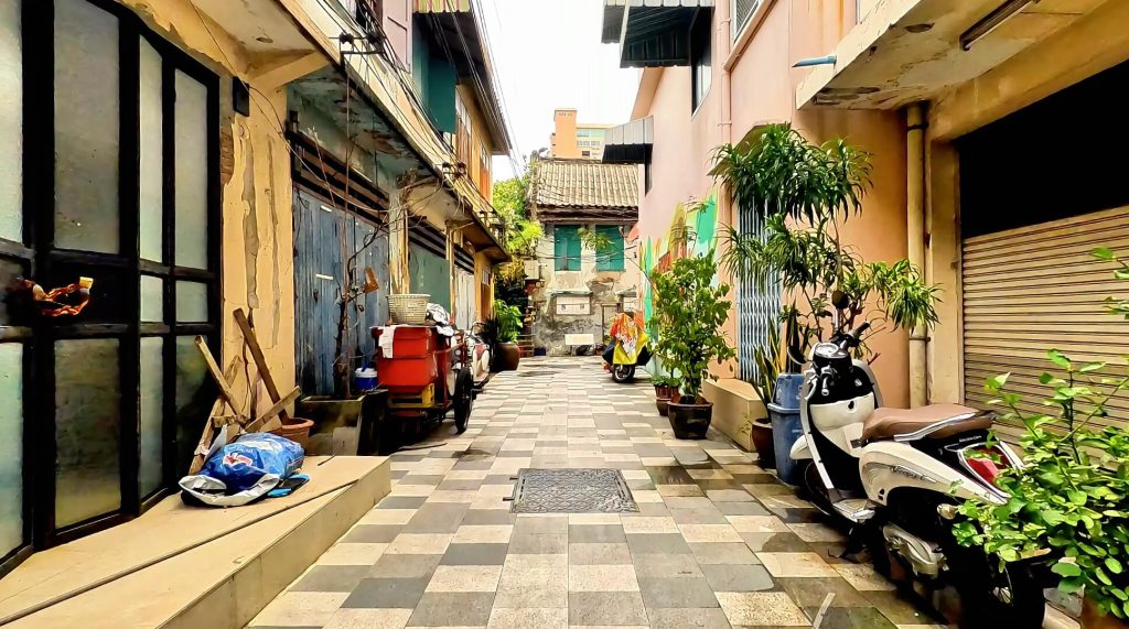 Narrow lane in Talat Noi Bangkok with traditional shophouses and local activity