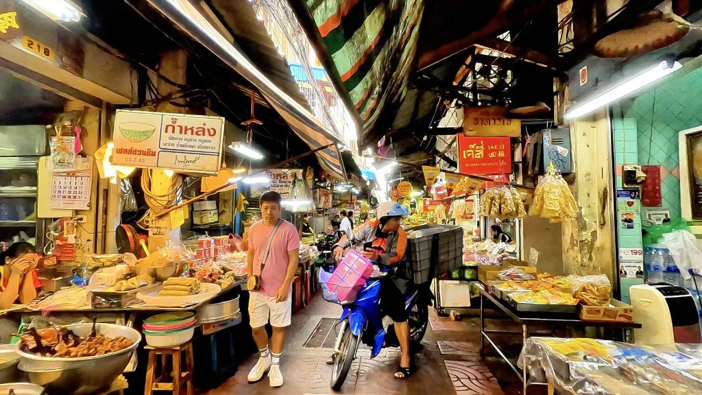 Street vendors and shoppers at Hua Met Market in Bangkok.