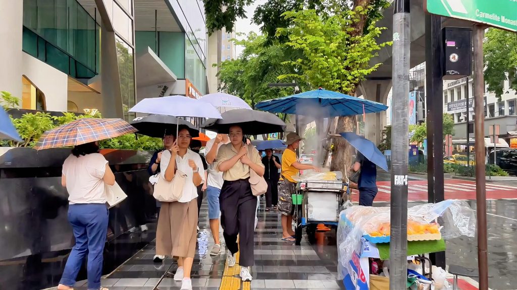 Office workers making their way to Sala Daeng BTS Station during the evening commute in Bangkok.