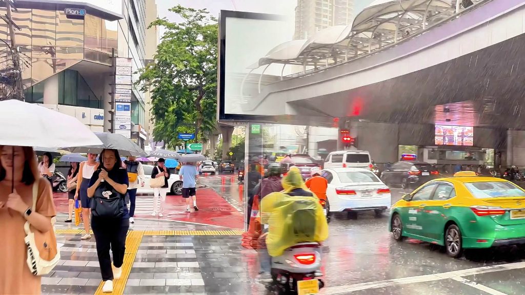Split view of Silom Road and Chong Nonsi Skywalk during Bangkok's evening commute, showing traffic, commuters and the central business district after work.