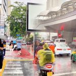 Split view of Silom Road and Chong Nonsi Skywalk during Bangkok's evening commute, showing traffic, commuters and the central business district after work.